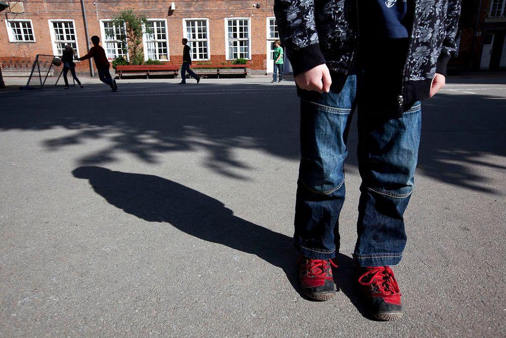 Person i skolegård fotografereret så kun benene er synlige